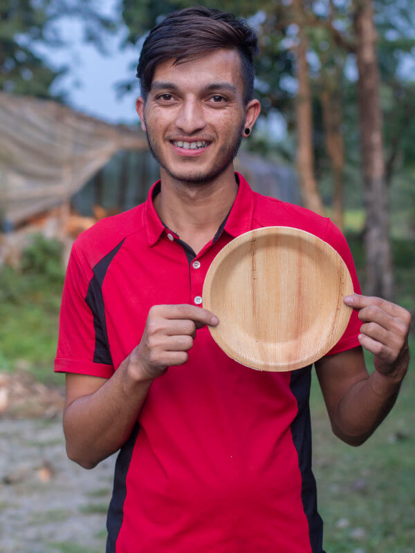 Person mit Teller aus Palmblatt Ramesh - 20cm